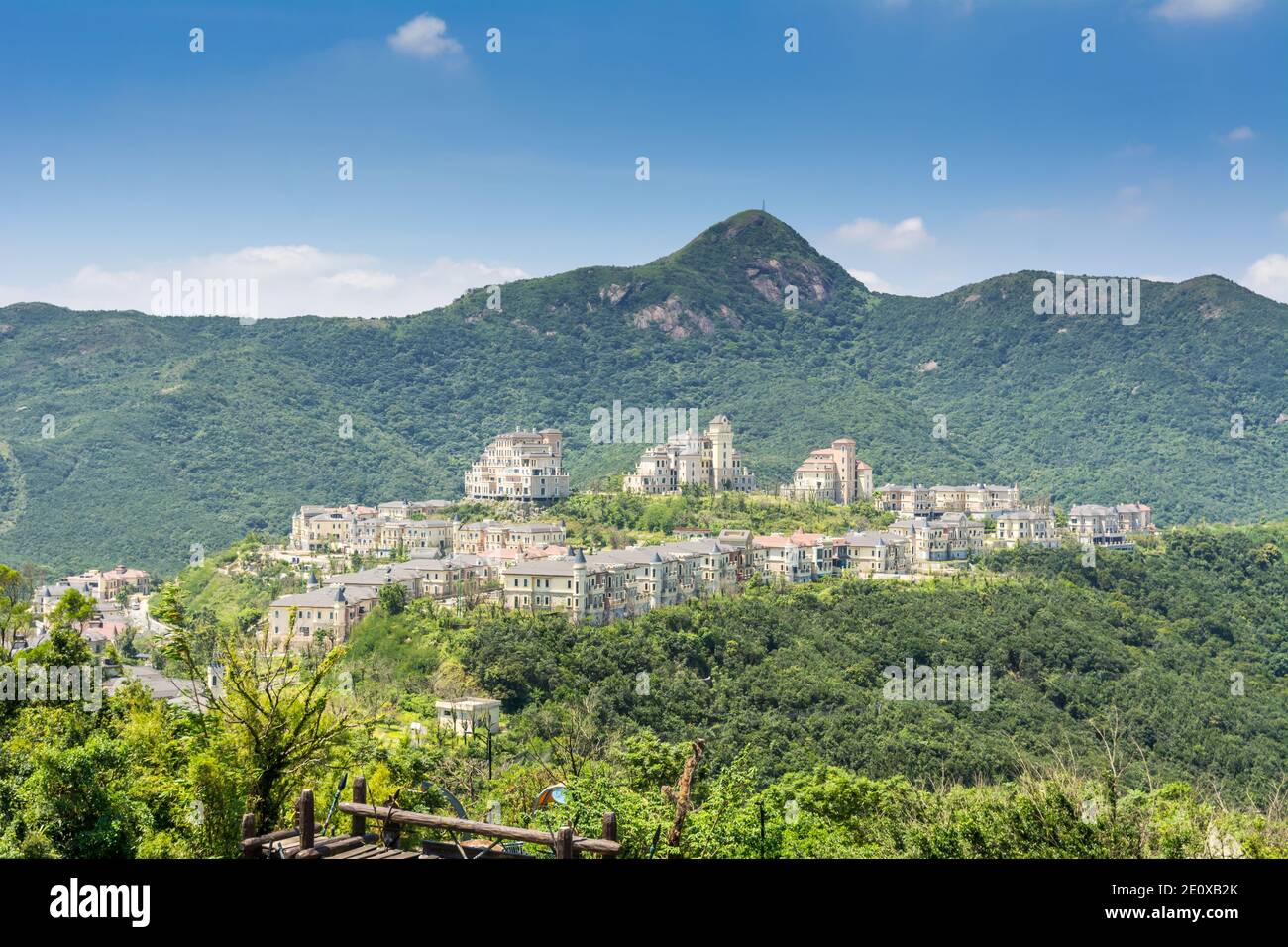 Modern castles on the top of mountain against cloudy sky in Overseas Chinese Town East  (OCT East ) in Shenzhen, Guangdong, China. [SPE2E0XB2K]