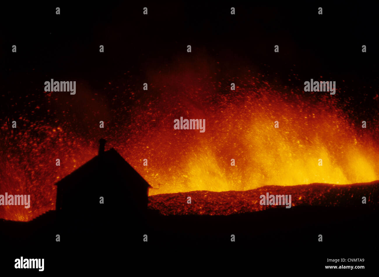 Volcanic eruption, erupting lava with town house silhouetted, Eldfell Volcano, Heimaey, Westmann Isles, Iceland, 1973 [SPECNMTA9]